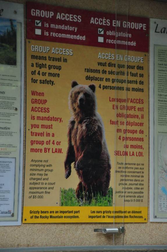 Aviso de que apenas grupos com 4 pessoas, no mínimo, podem caminhar nessa área na região de Lake Louise, em Alberta, no Canadá